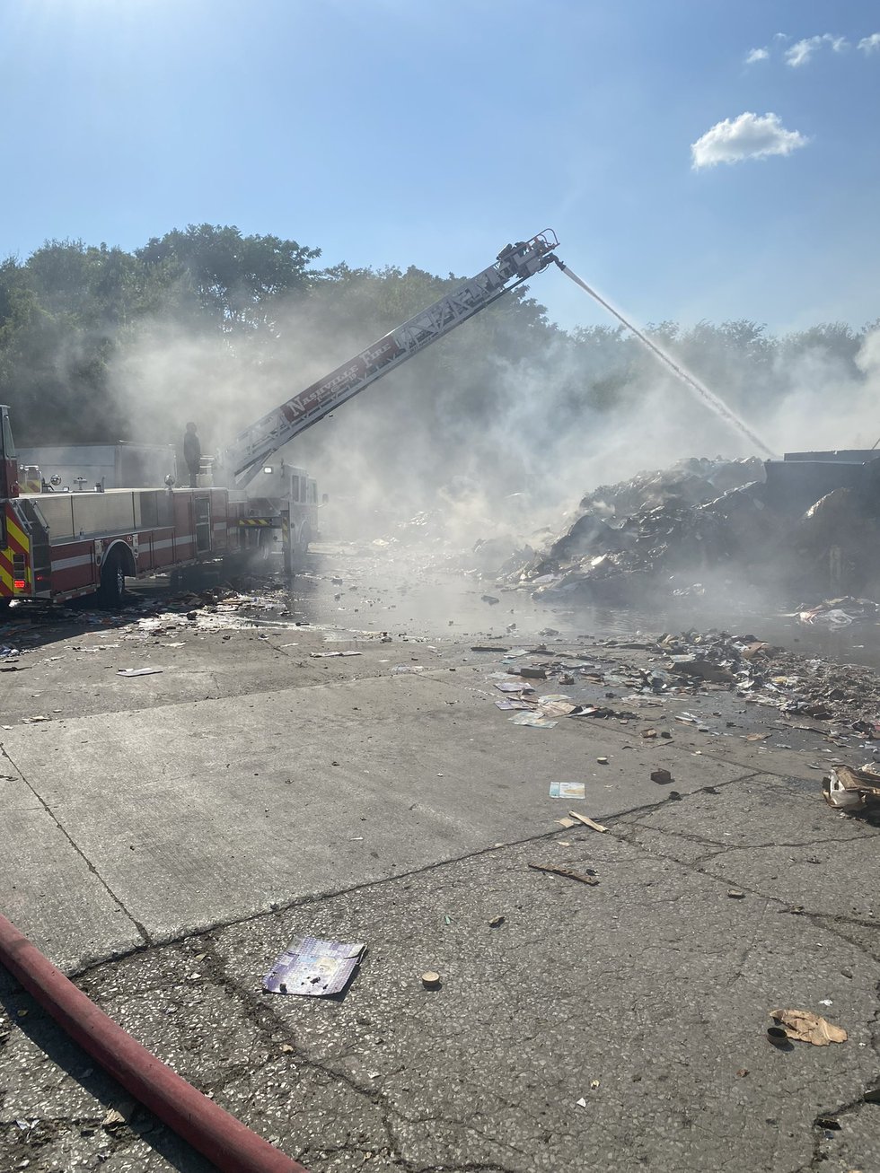 Crews work to extinguish recycling center fire.