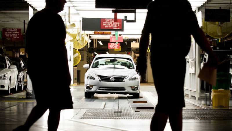 Workers at the Nissan plant in Smyrna, Tenn., walk by a Nissan Altima sedan, May 15, 2012. A...