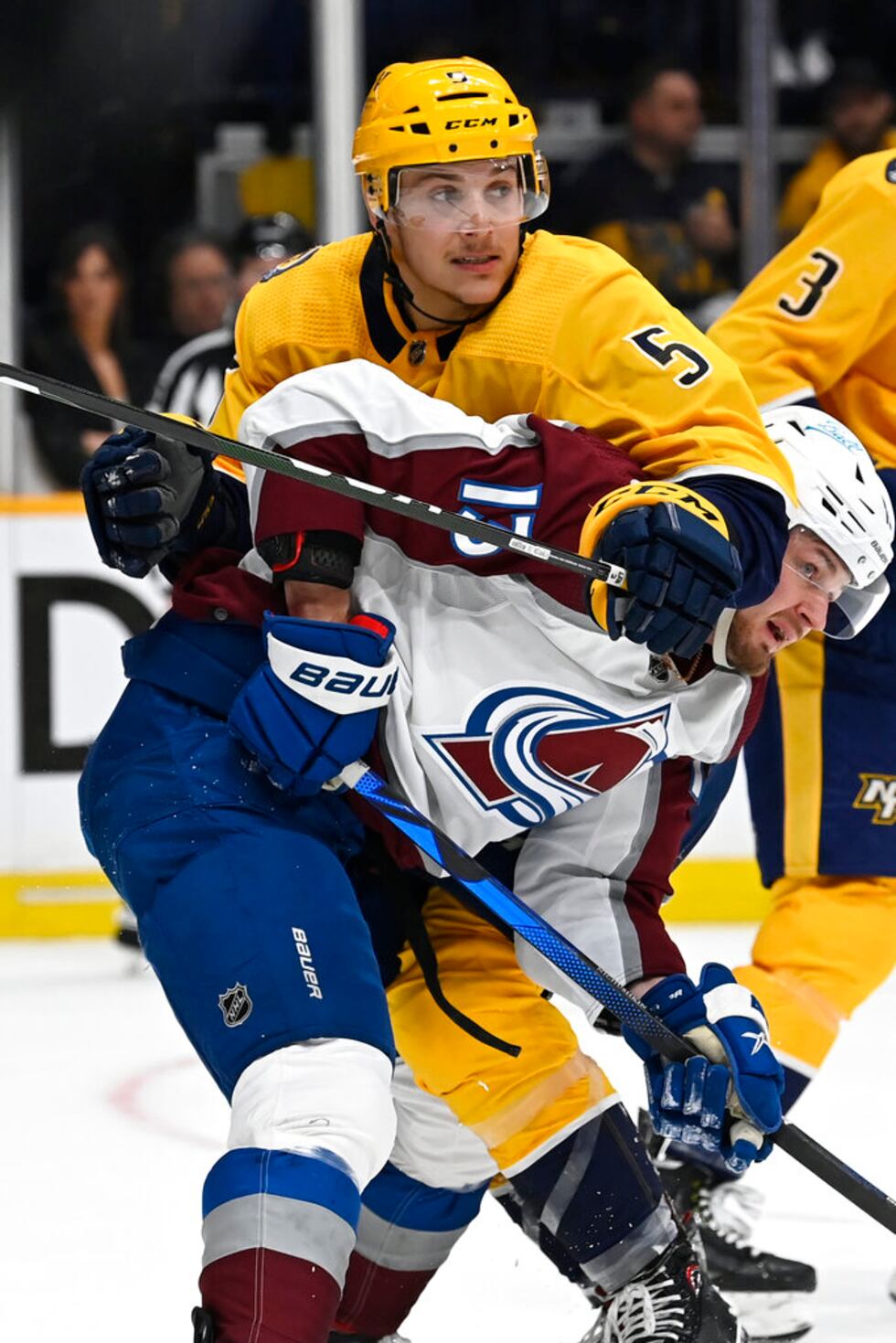 Nashville Predators defenseman Matt Benning (5) gets tangled up with Colorado Avalanche right...