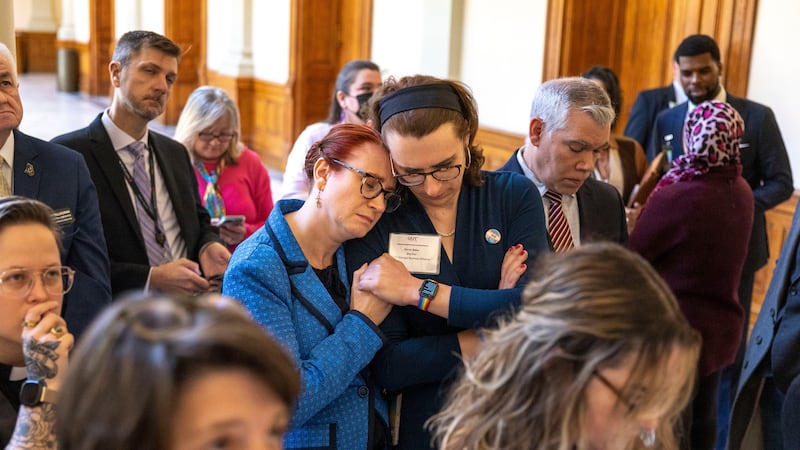 FILE - Jennifer Bowie, center left, and Aaron Baker, center right, become emotional while...