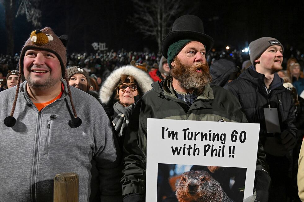 Rory Szwed, left, and Kent Rowan watch the festivities while waiting for Punxsutawney Phil,...