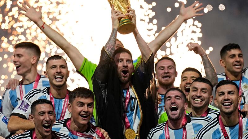 Argentina's Lionel Messi lifts the trophy after winning the World Cup final soccer match...